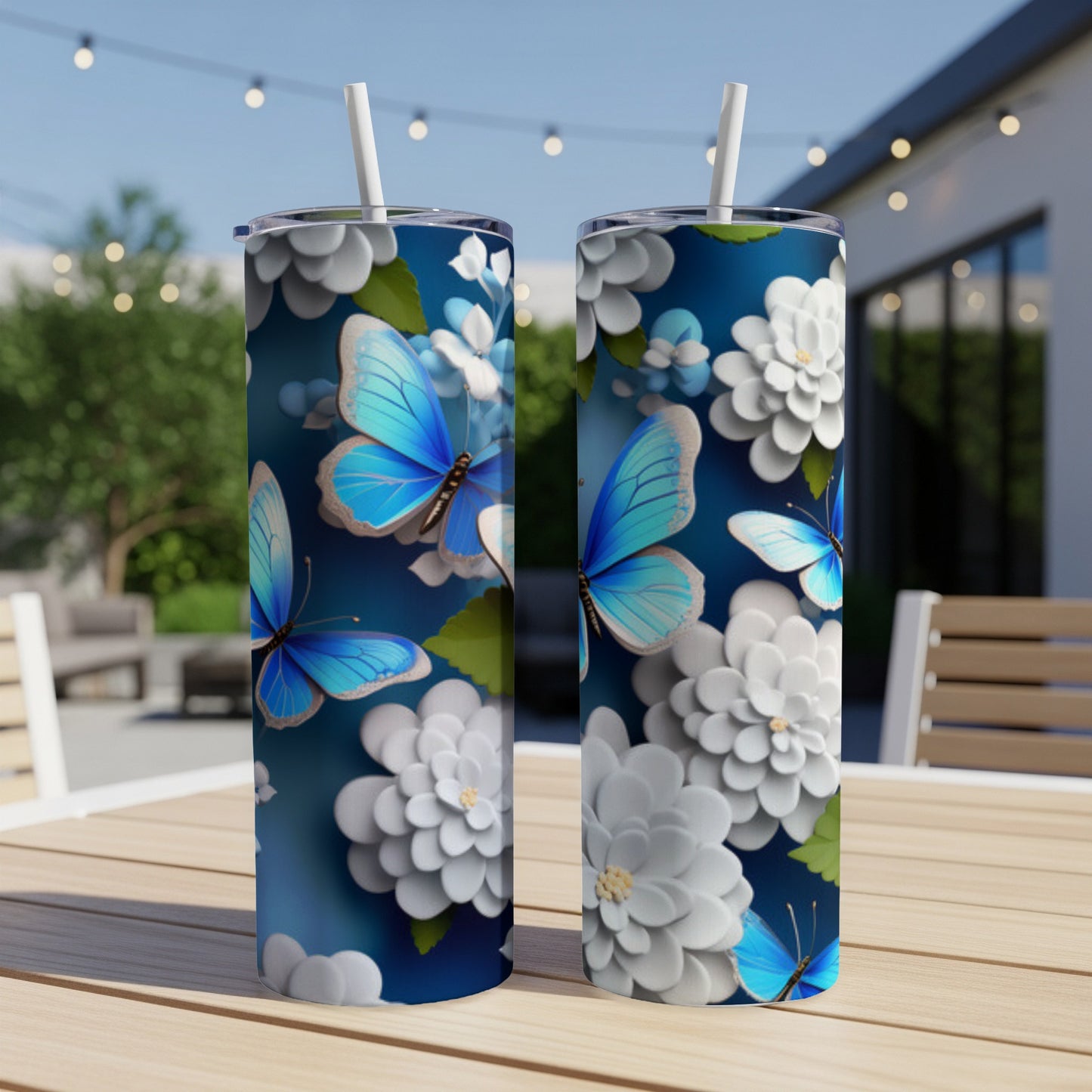 Two tall tumblers with blue butterflies and white flowers on a dark blue background.