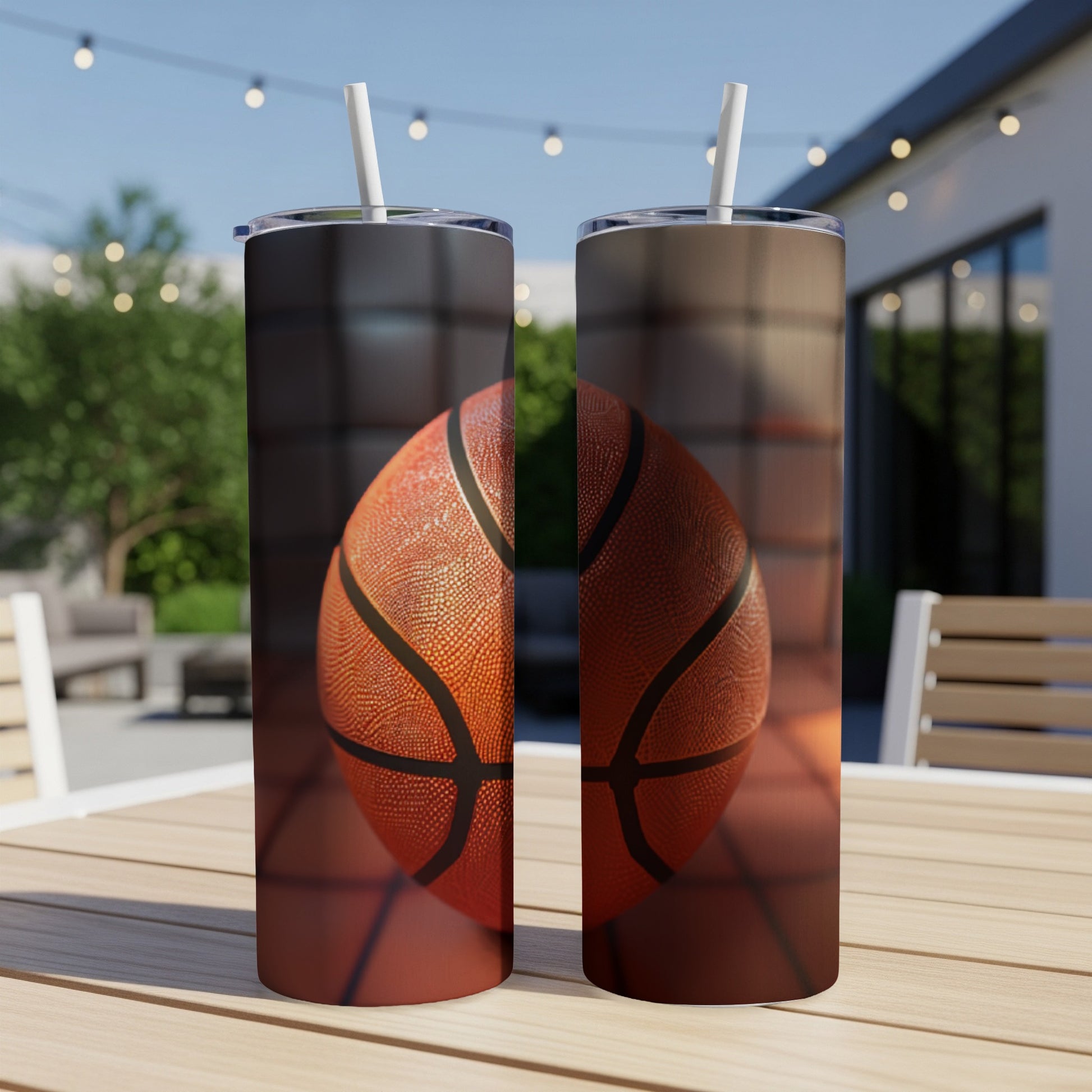 Two tumblers with basketball graphics on a wooden table outdoors.
