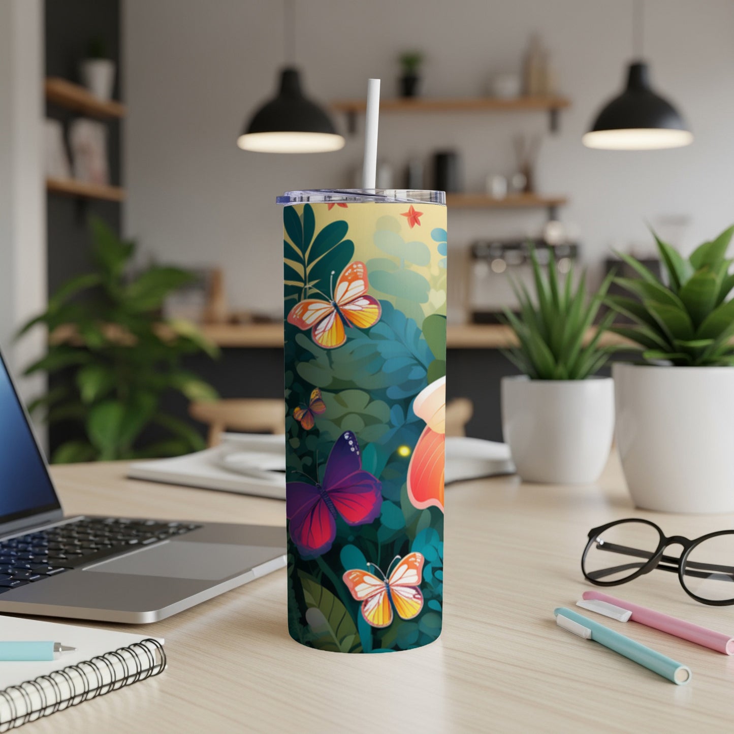 Tall tumbler with colorful butterflies and floral design on desk.