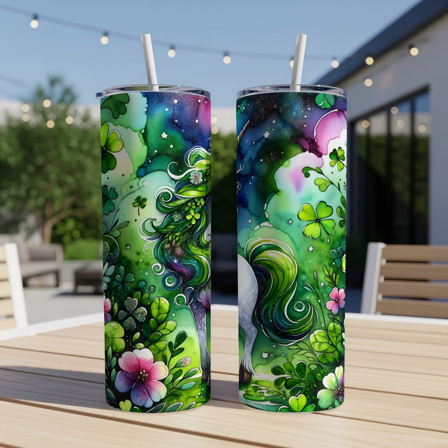 Two green tumblers with unicorn, shamrocks, and flowers on outdoor table.
