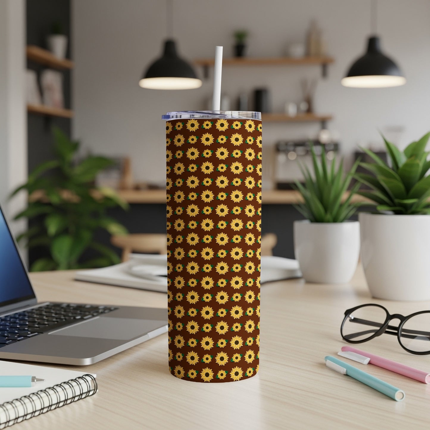 Brown tumbler with repeating sunflower pattern and white straw.