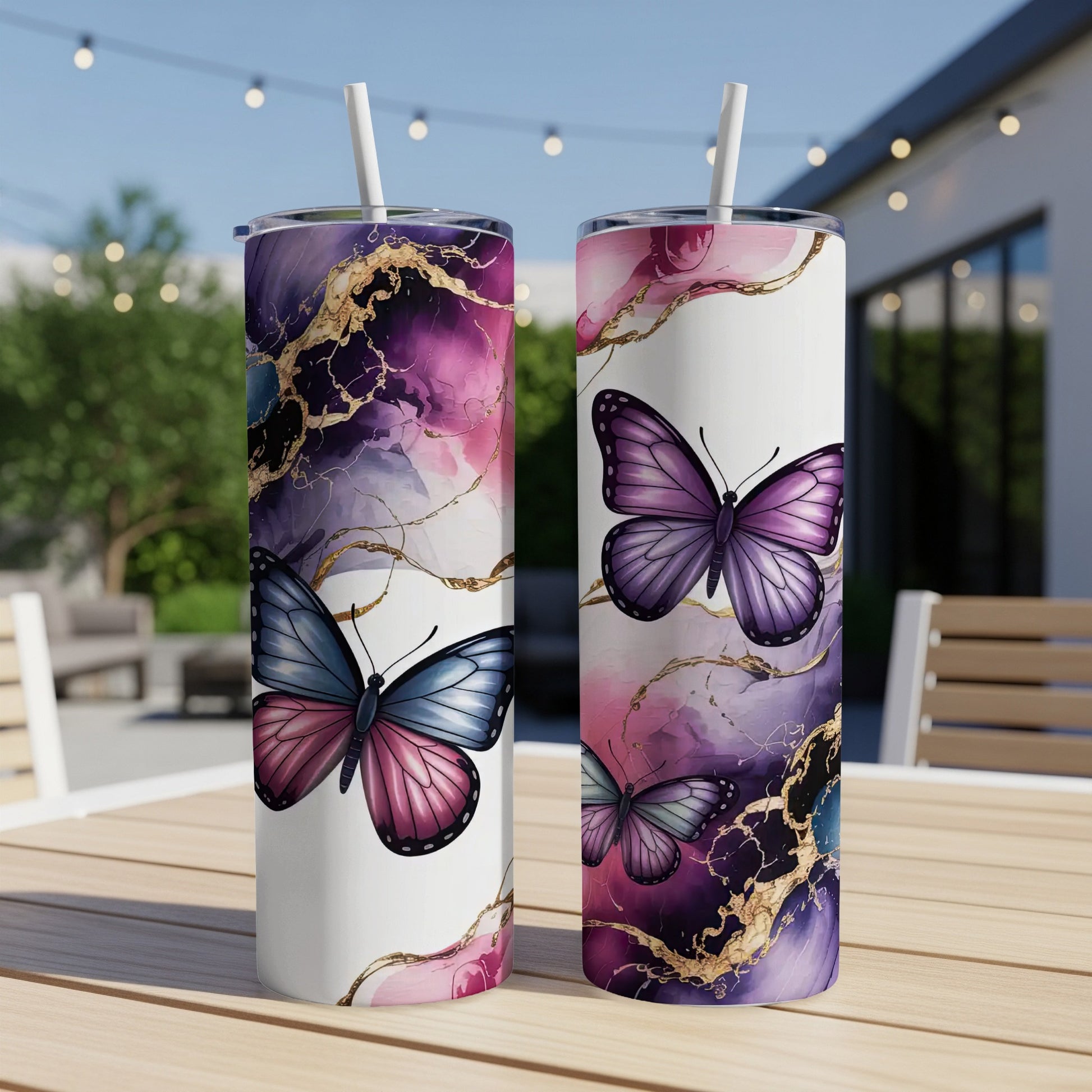 Two white tumblers with purple and gold abstract marble design and butterflies.