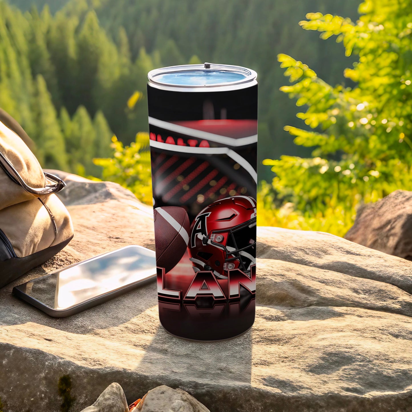 Tumbler featuring a football helmet and "LAN" text, resting on rocks.