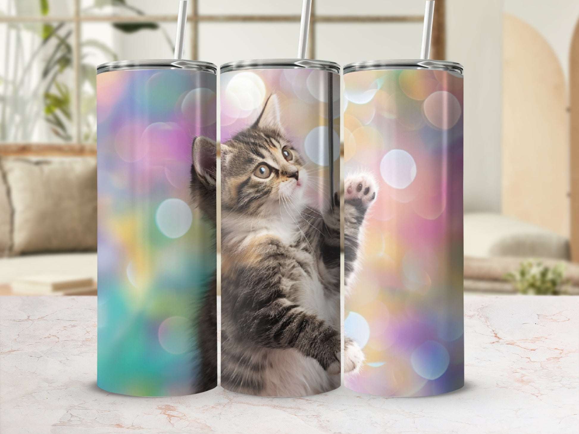 Three tumblers featuring a playful kitten against a bokeh background.