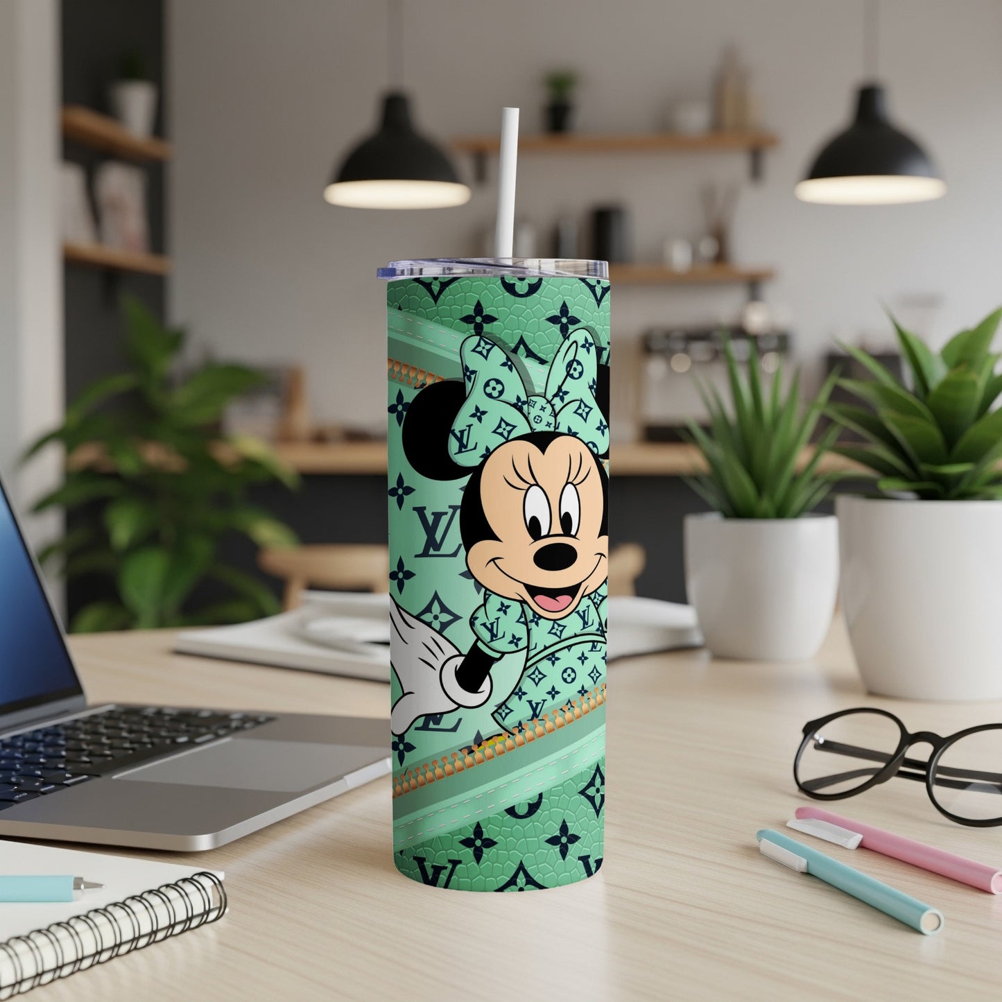 Minnie Mouse on a green tumbler with LV pattern, standing on a desk.