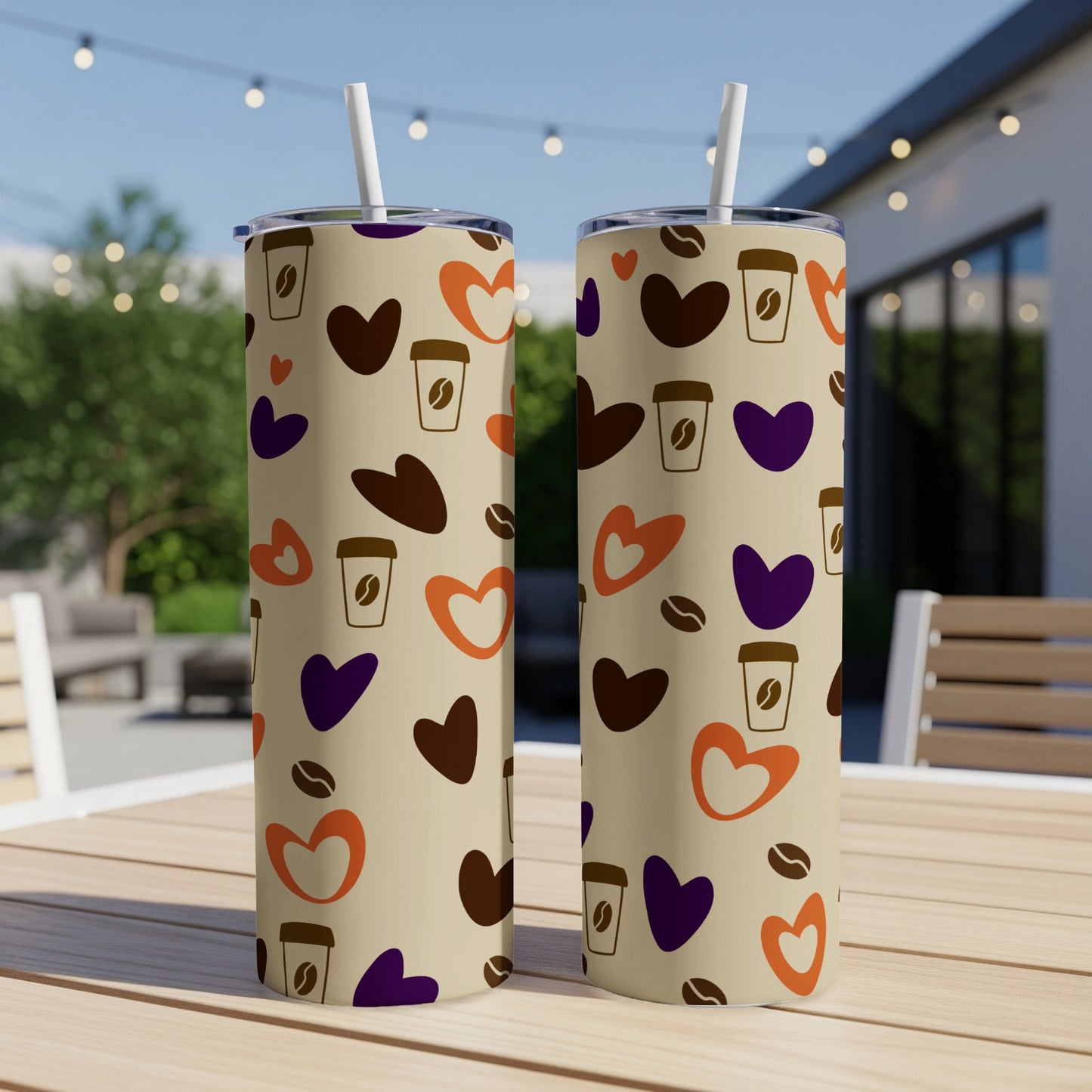 Two tall tumblers with heart and coffee cup pattern on a table.