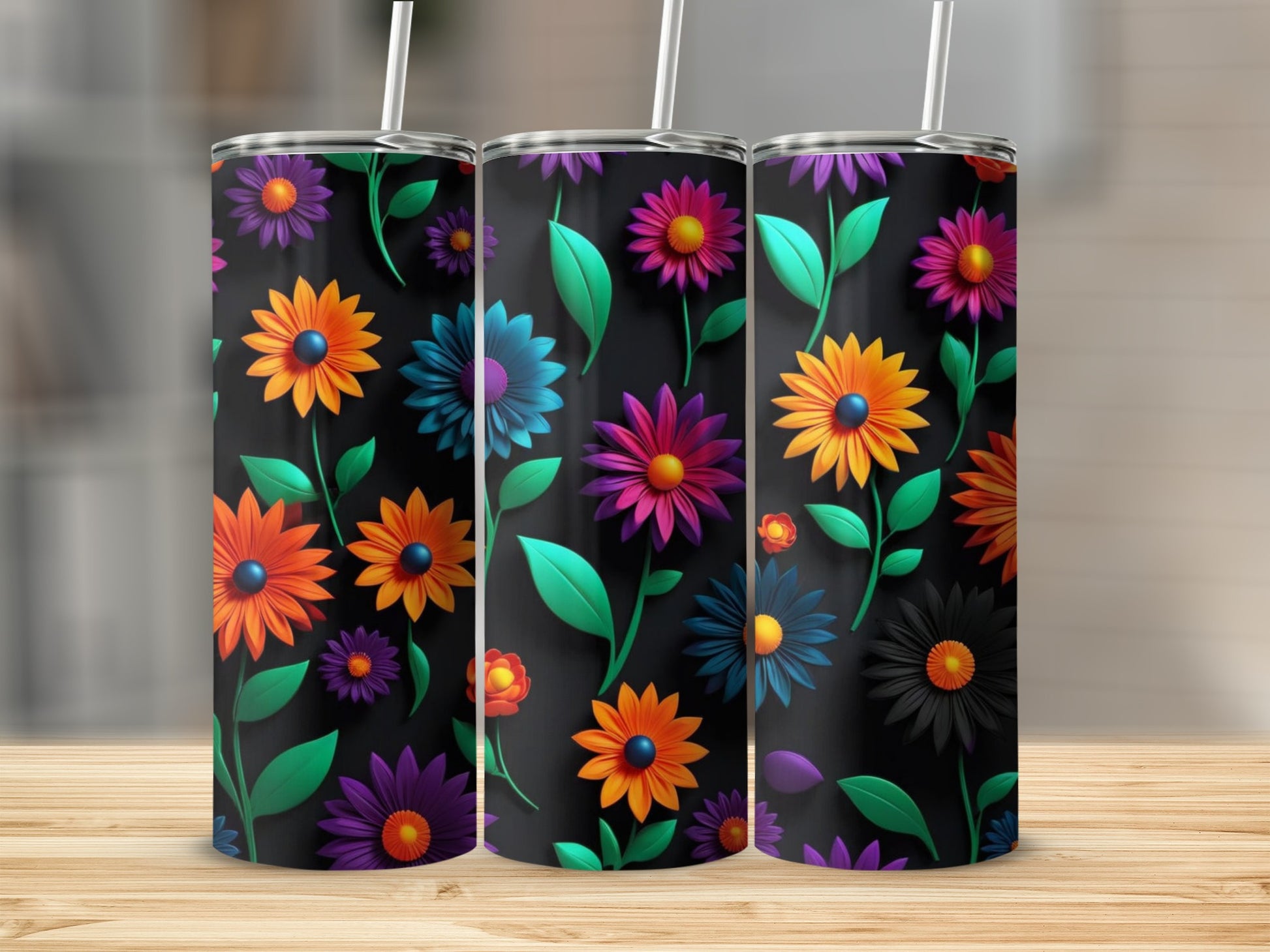 Three tumblers with a vibrant floral pattern on a wooden surface.