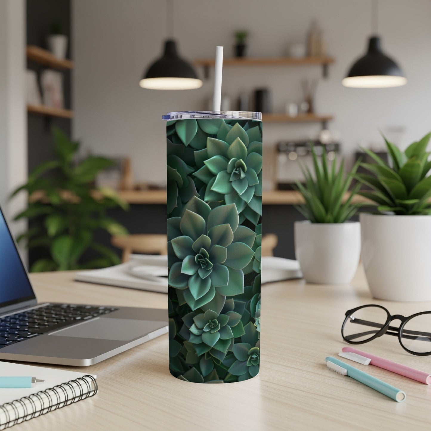 Green succulent plants covering a white tumbler with straw on a desk.