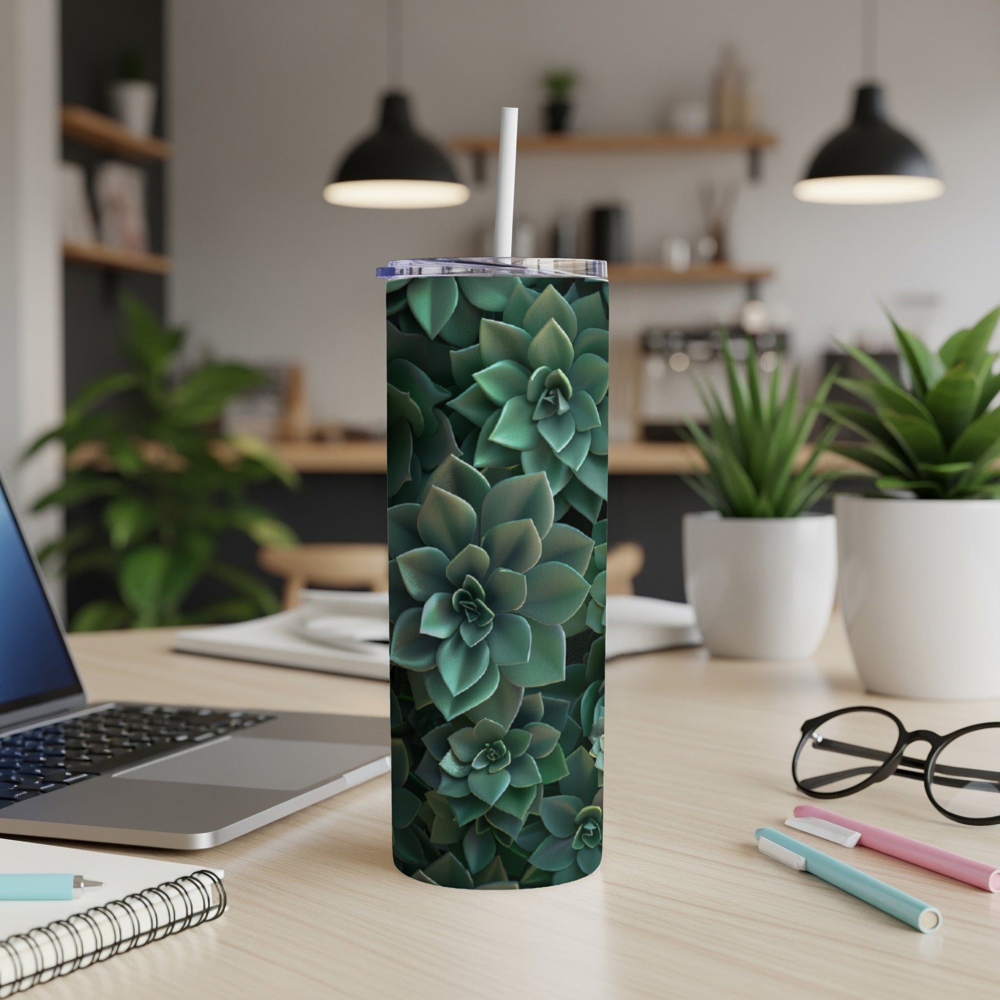 Green succulent plants covering a white tumbler with straw on a desk.