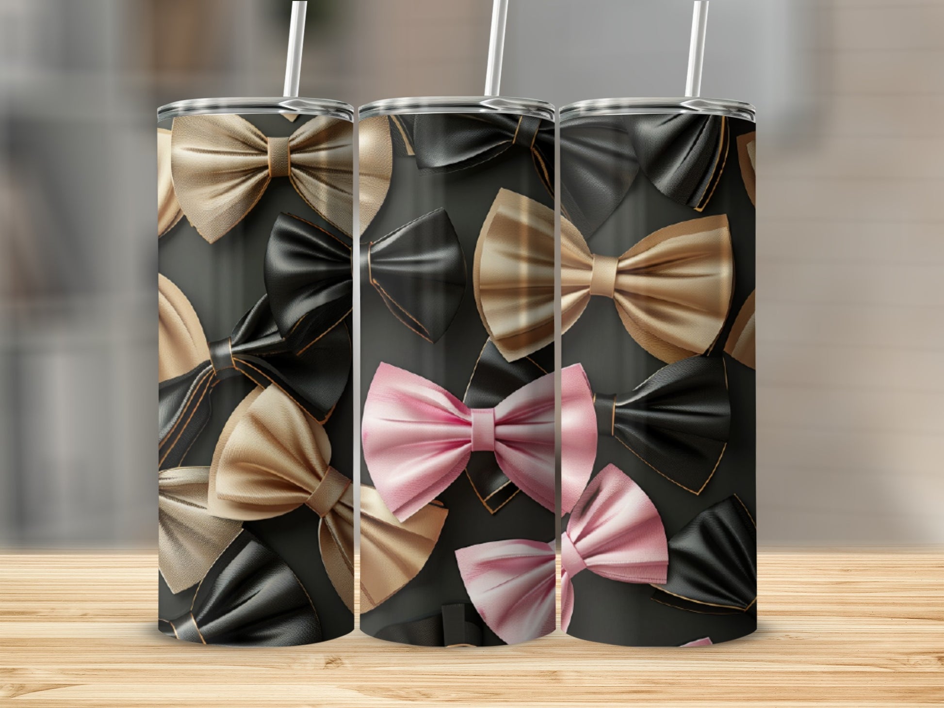 Three tumblers with bow patterns in gold, pink, and black.