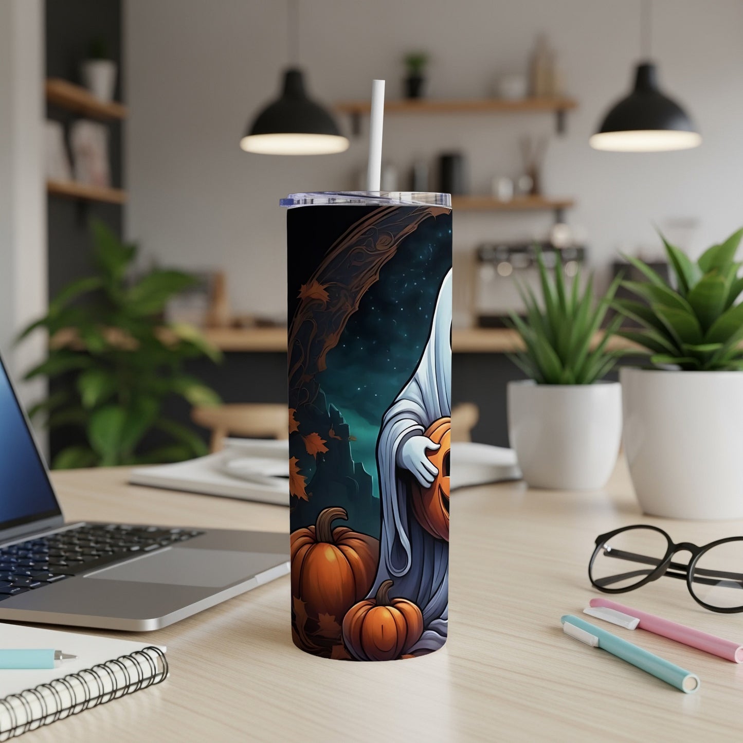 Ghost holding a pumpkin on a tumbler with Halloween scene.