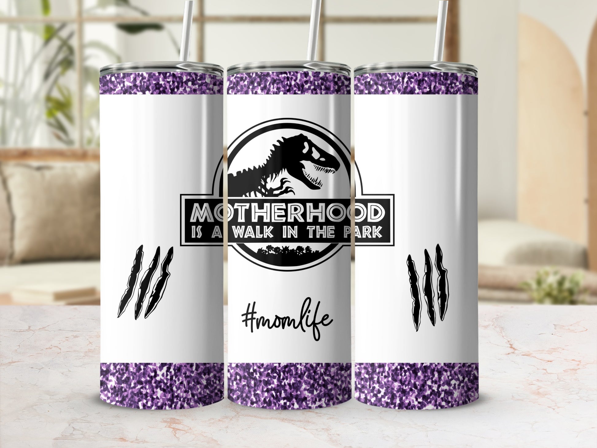 White tumbler with purple glitter, dinosaur logo, and #momlife text.