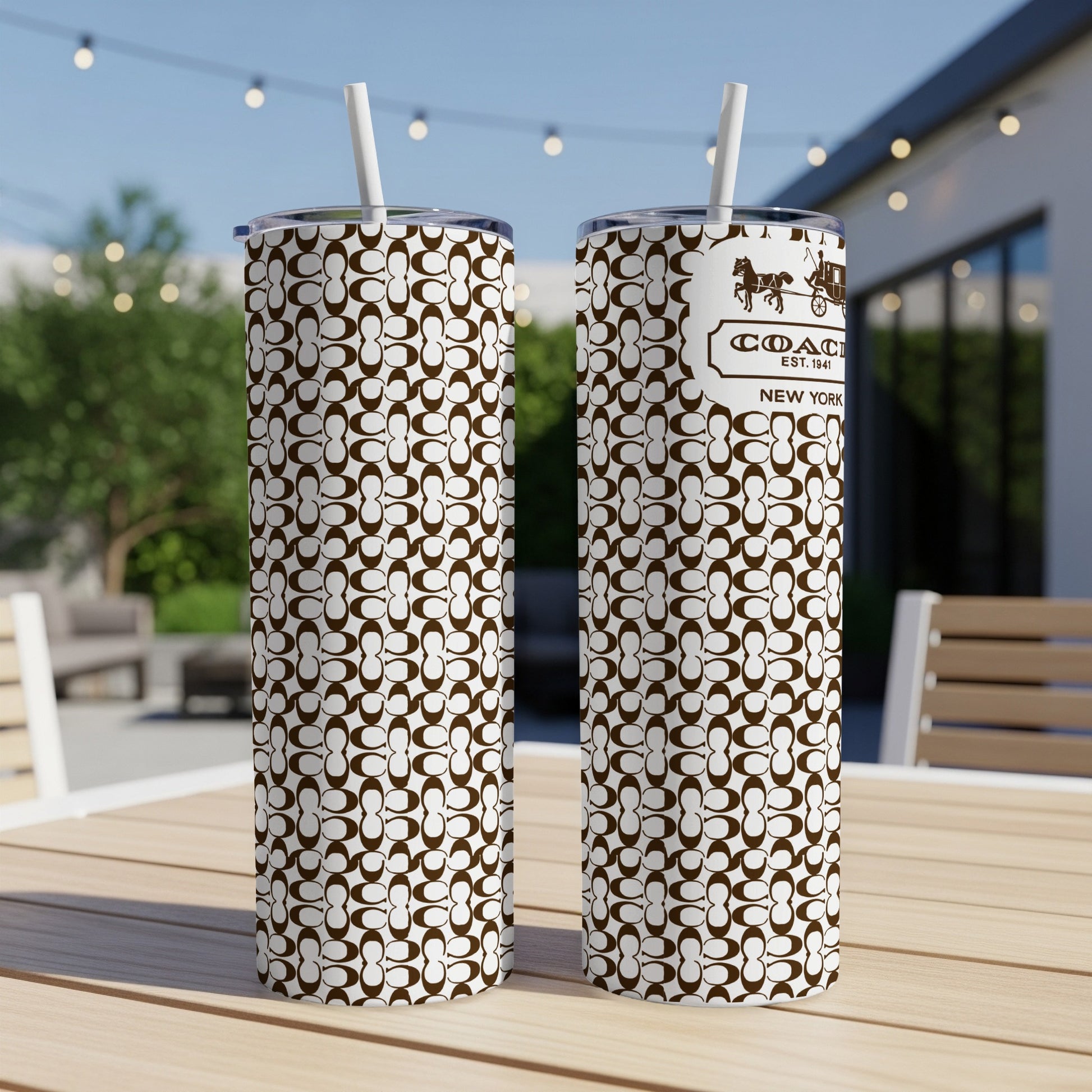 Coach New York tumbler with brown and white monogram pattern and straw.