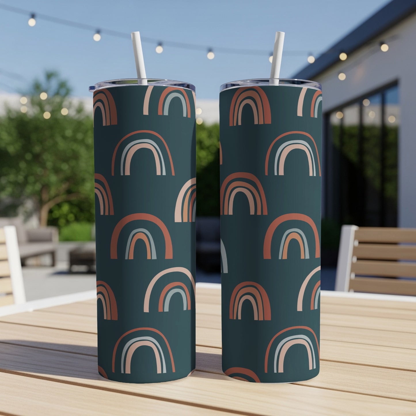 Two tumblers with a dark teal background and a repeating pattern of muted rainbows.