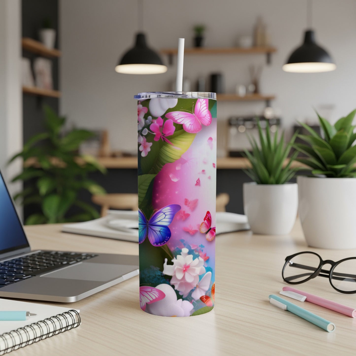 Pink and purple butterfly design on a white skinny tumbler with a straw.