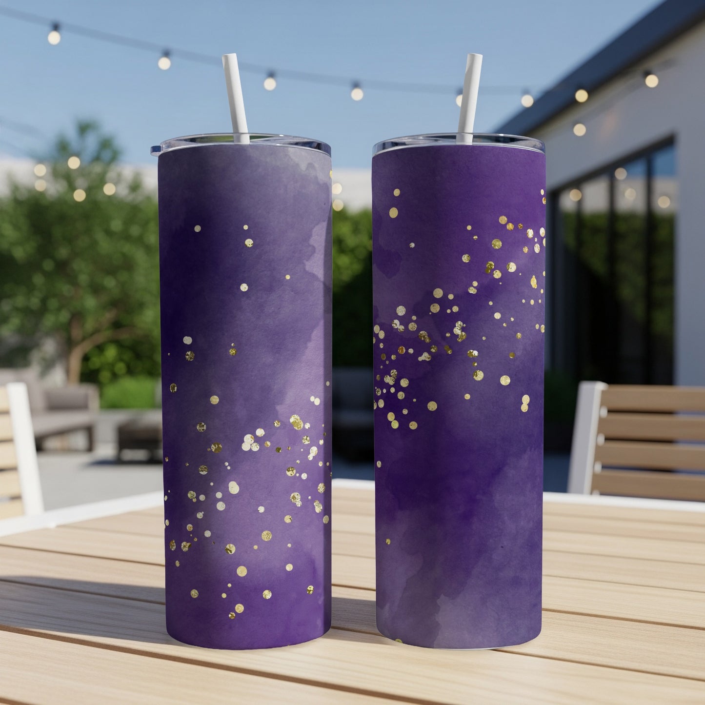 Two purple tumblers with gold glitter accents on a table.