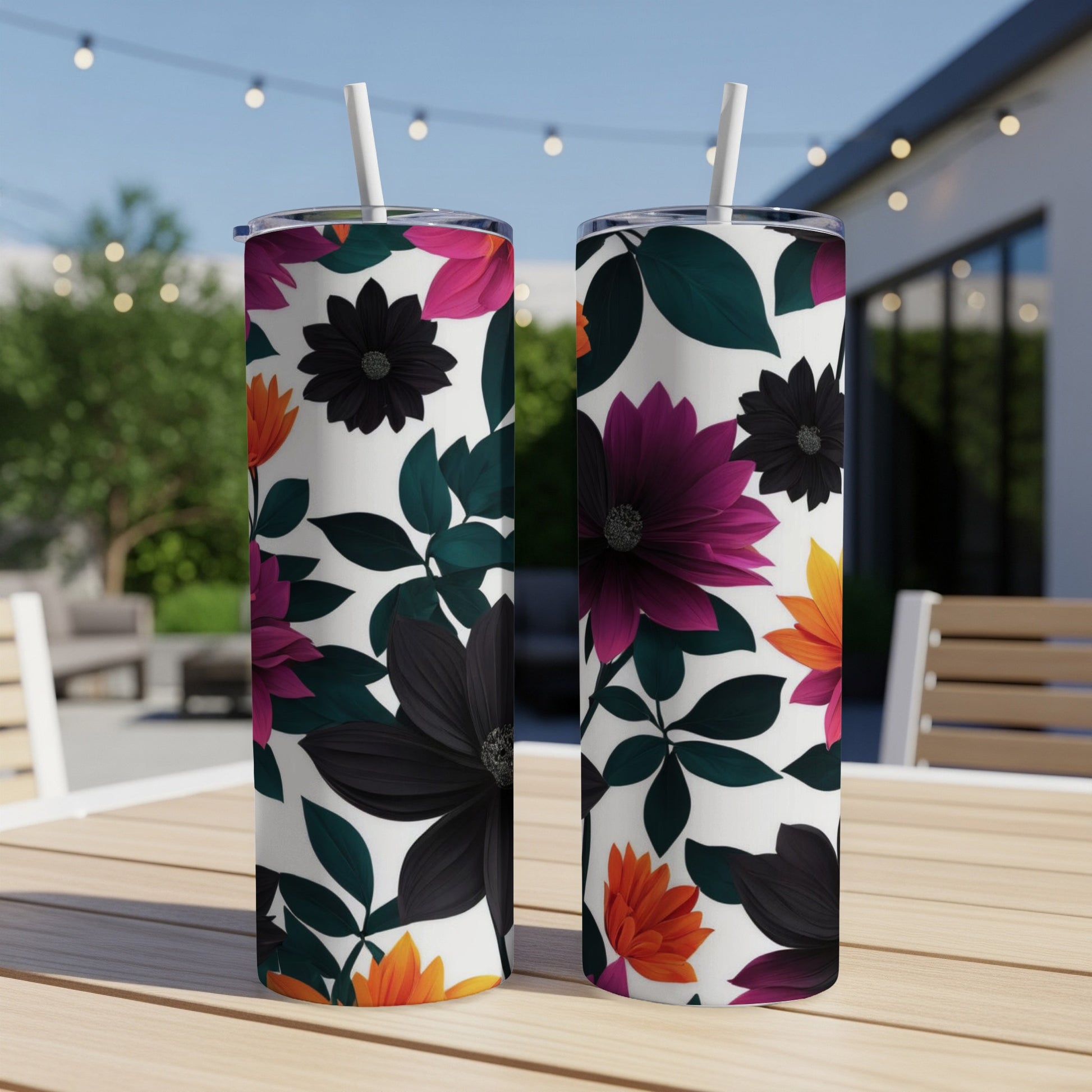Two white tumblers with colorful floral patterns sit on a table.