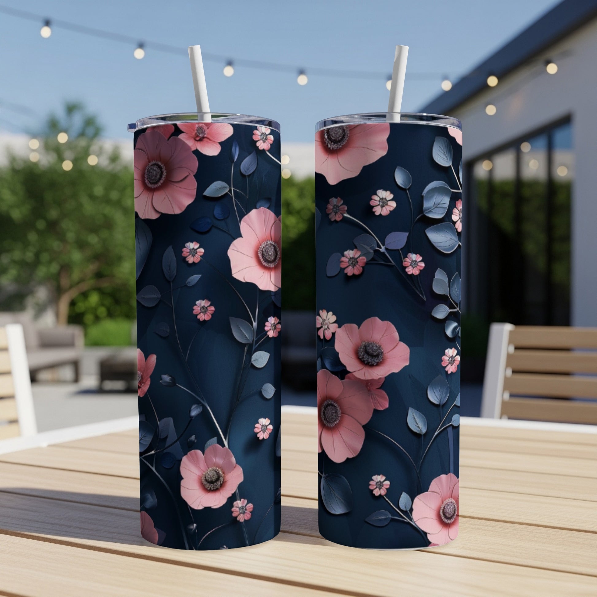 Two dark blue tumblers with pink floral and leaf design.