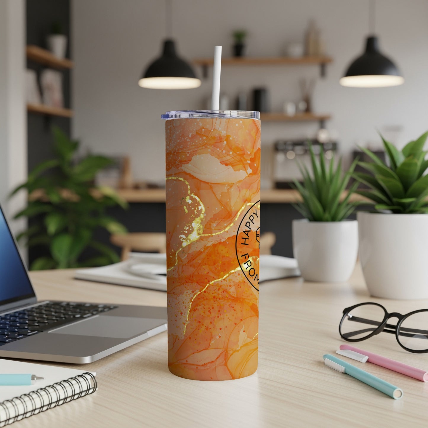 Marble patterned tumbler with "Happy from..." text, on a desk with a laptop.