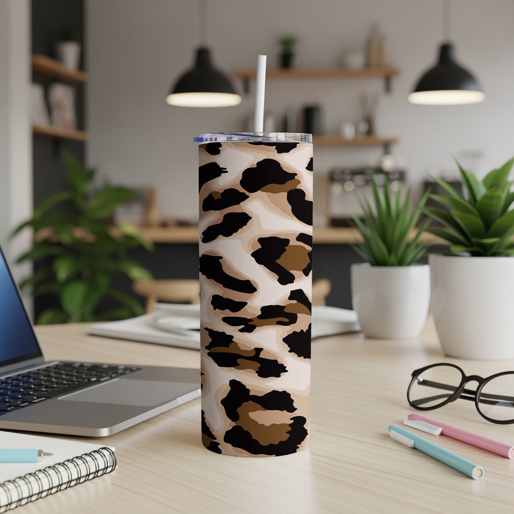 Tall tumbler with leopard print and white straw on a desk.