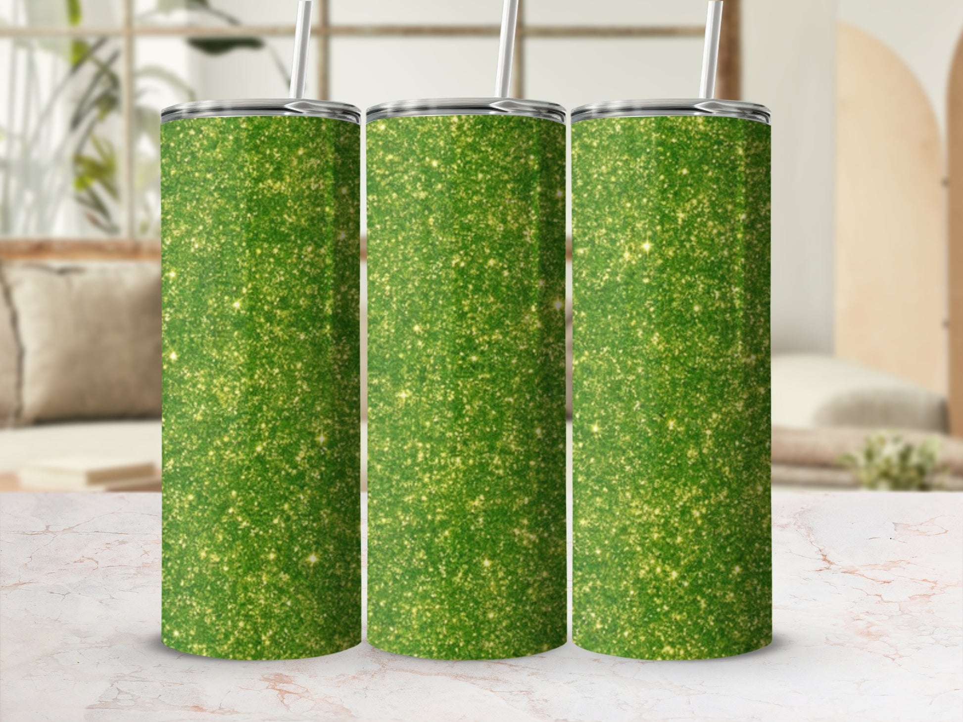 Three green glitter tumblers with straws stand in a row.
