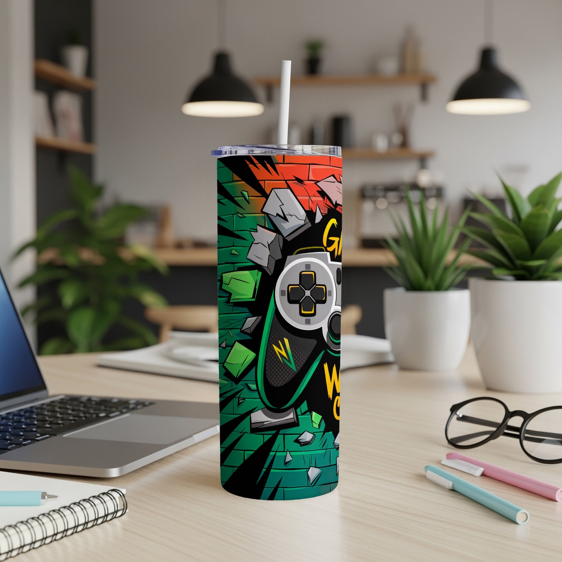 Gaming controller design on a tumbler with a straw, on a desk.