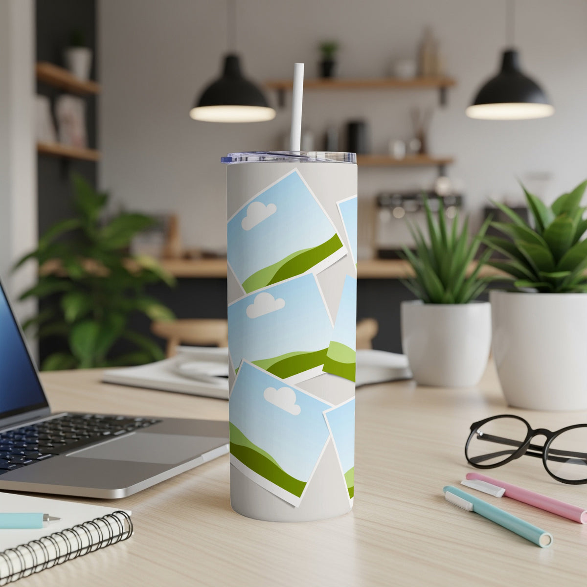 White tumbler with a collage of landscape photos and a straw.