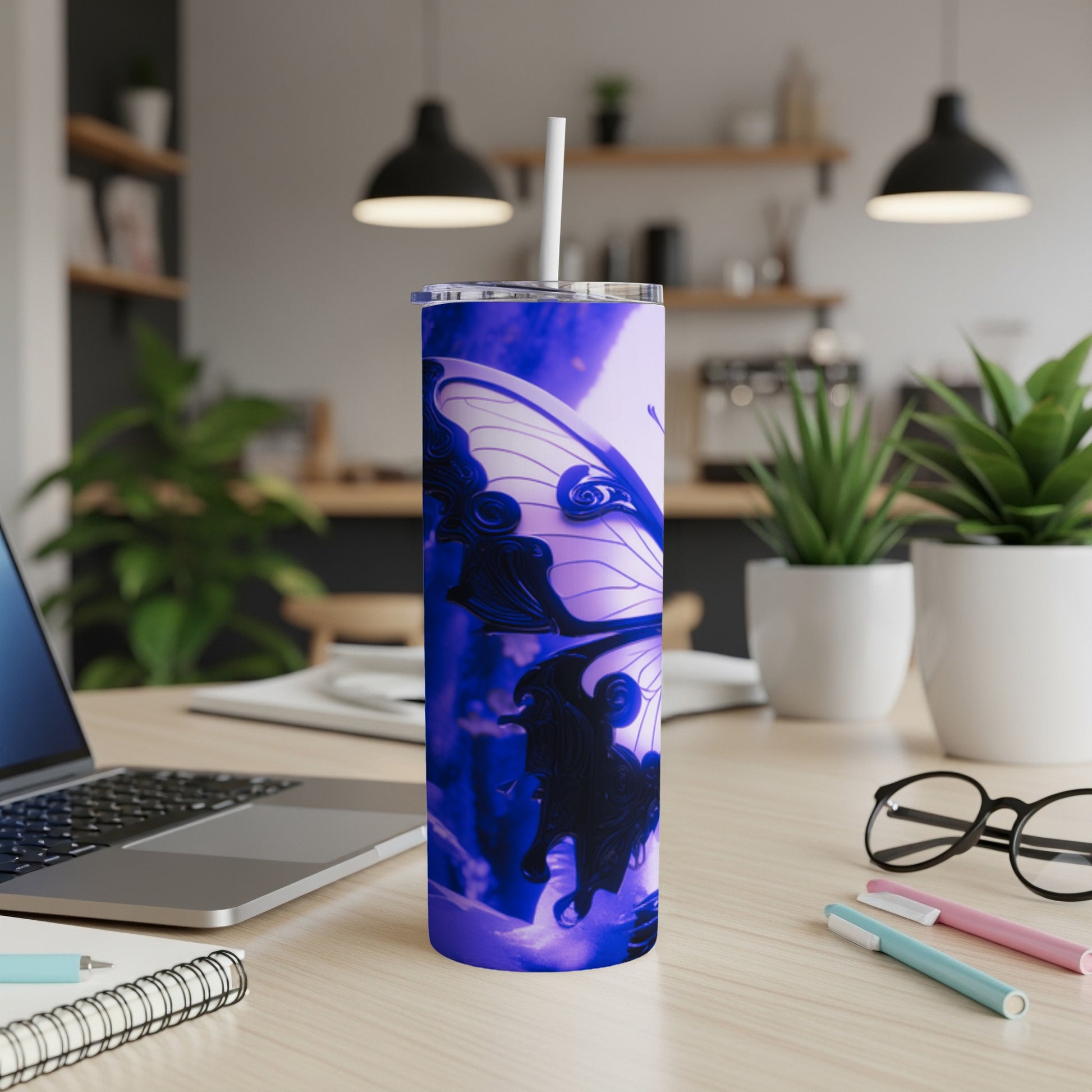 Blue butterfly tumbler with straw on a desk.