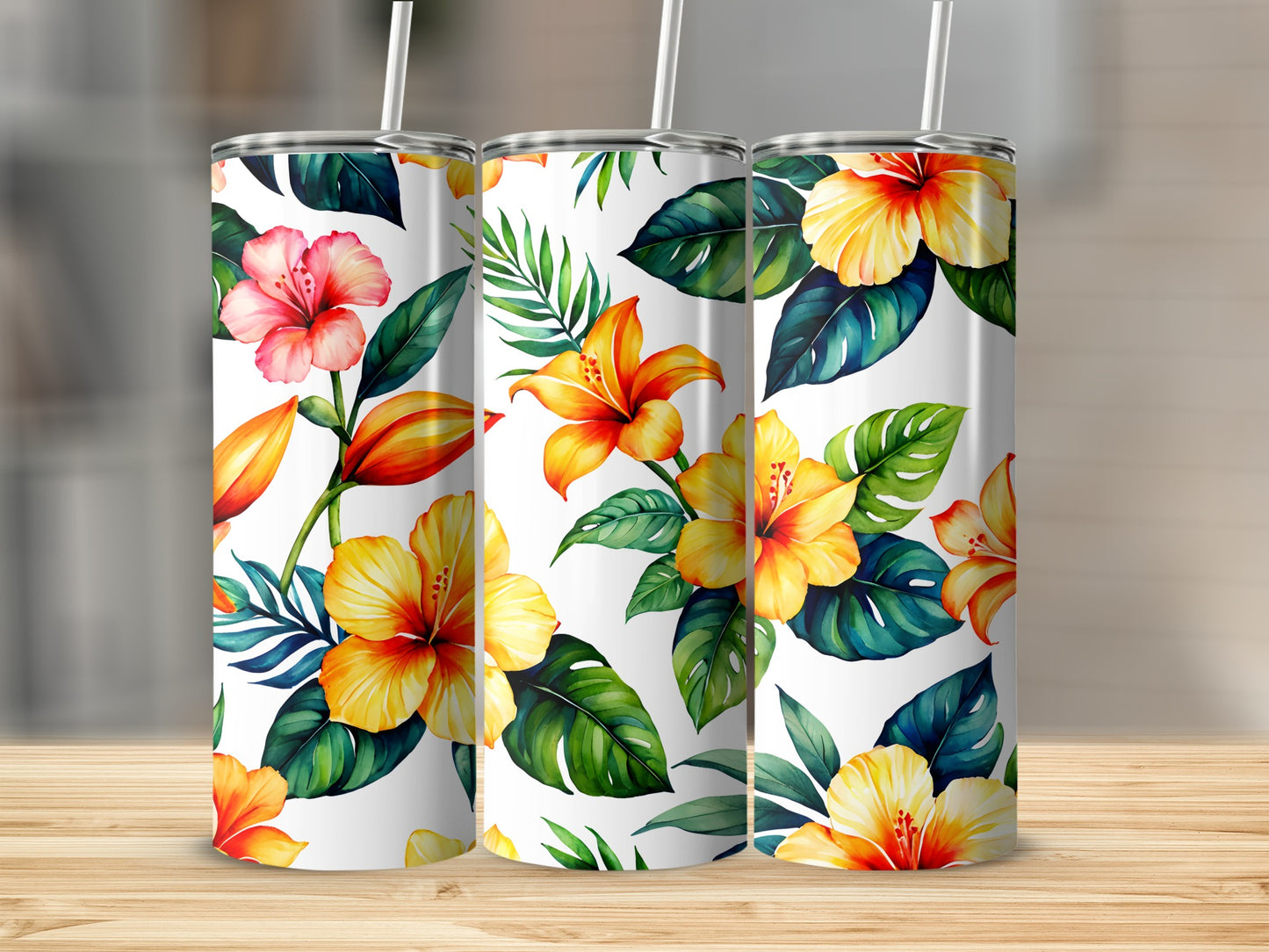 Floral hibiscus and palm leaves pattern on three white tumblers with straws.