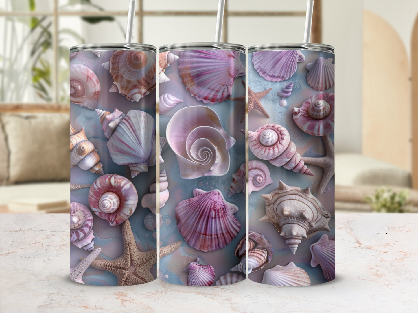Three tumblers featuring seashell and starfish designs on a marble surface.