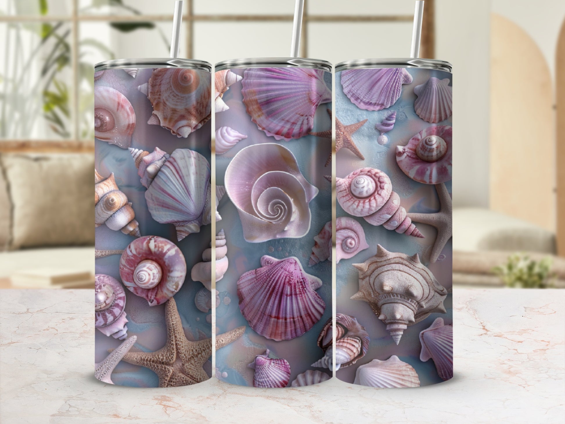 Three tumblers featuring seashell and starfish designs on a marble surface.