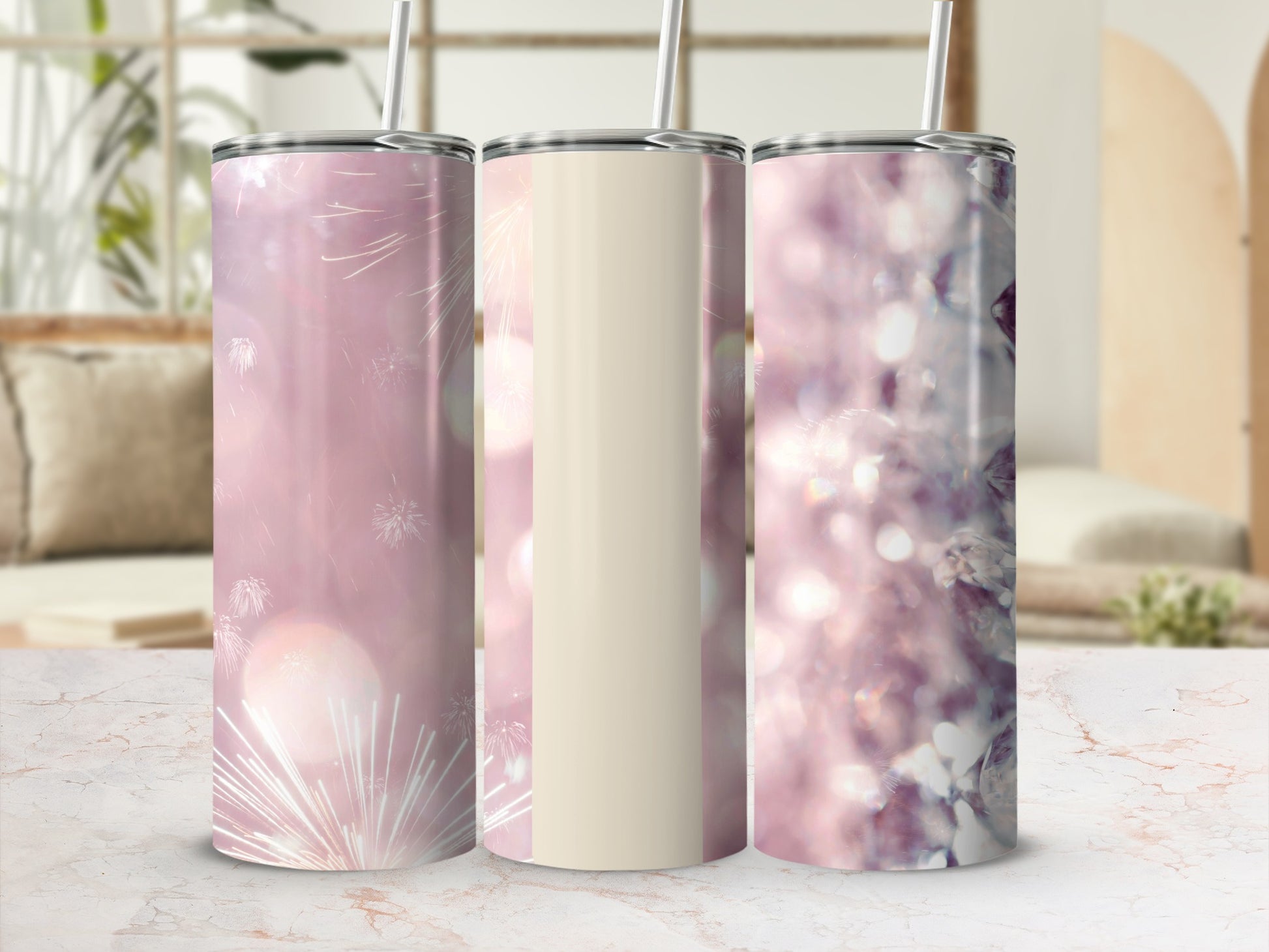 Three tumblers with blurred bokeh and firework backgrounds on a marbled surface.