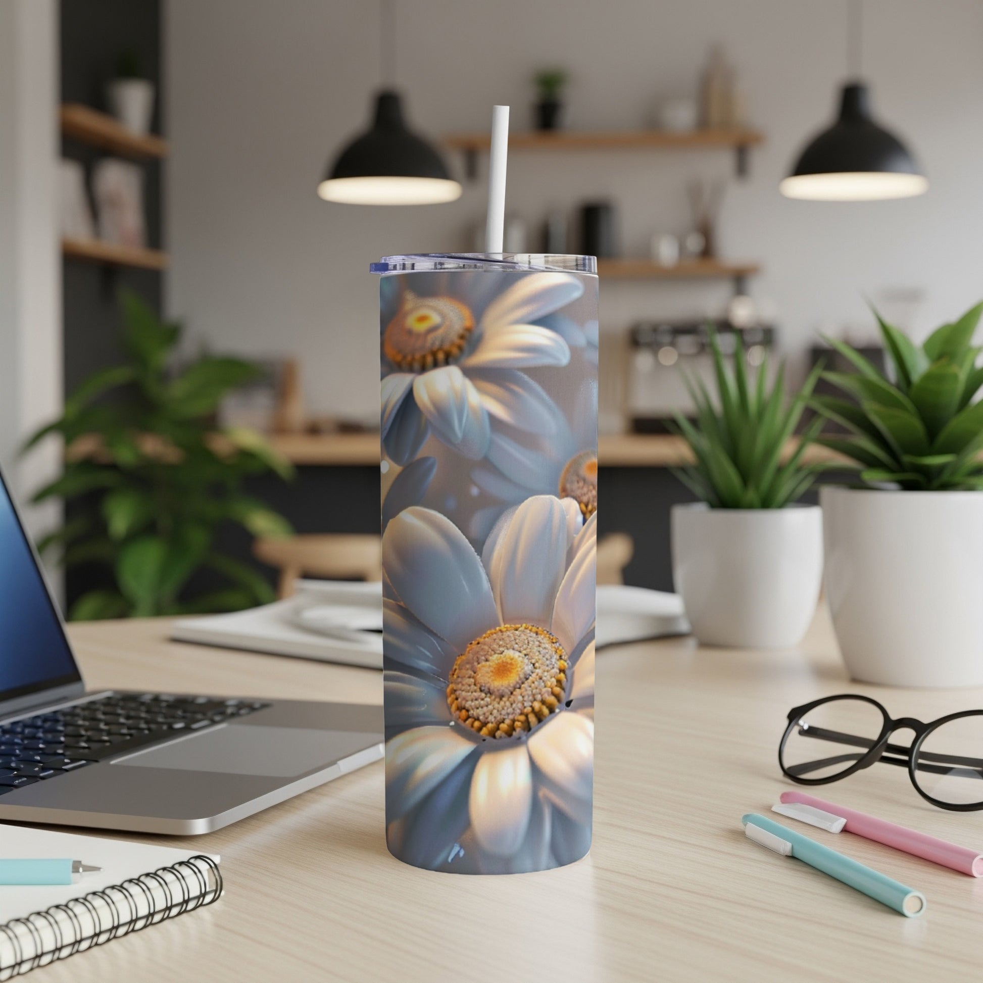 White daisy flower tumbler with straw on desk.