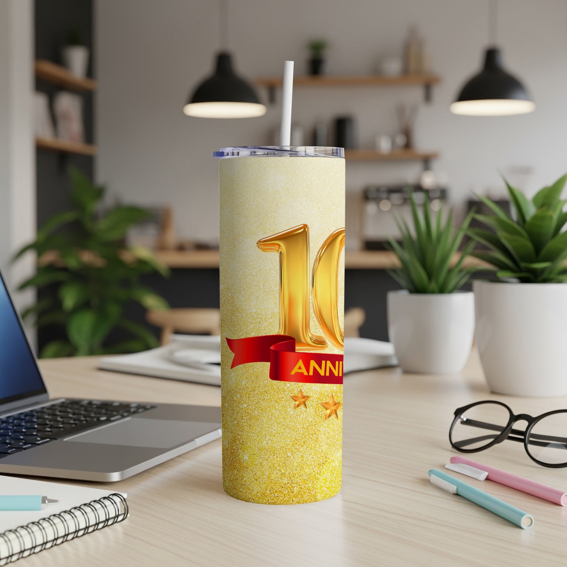 Gold 10th Anniversary tumbler with red ribbon and stars.