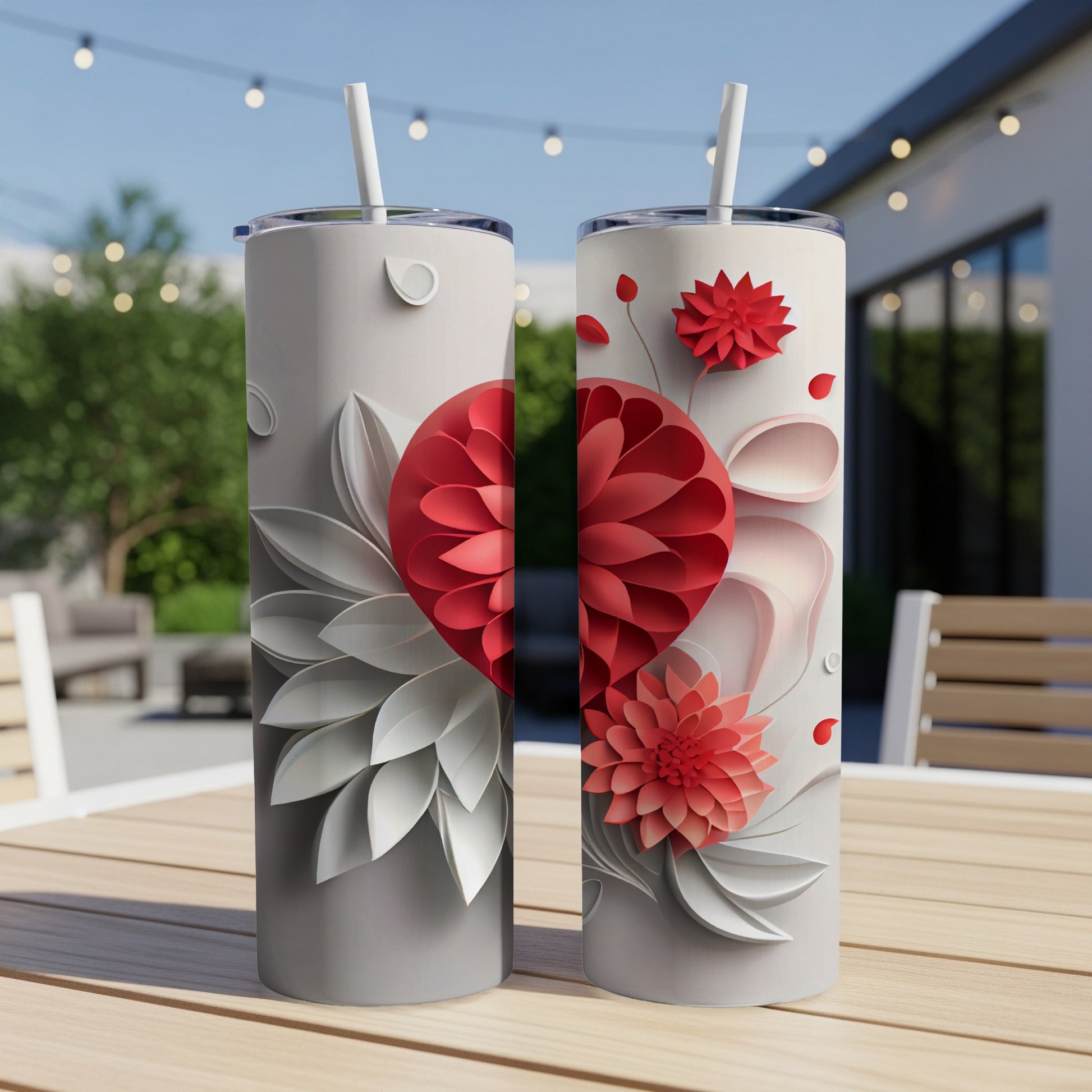 Two white tumblers with red and white floral designs sit on a table.