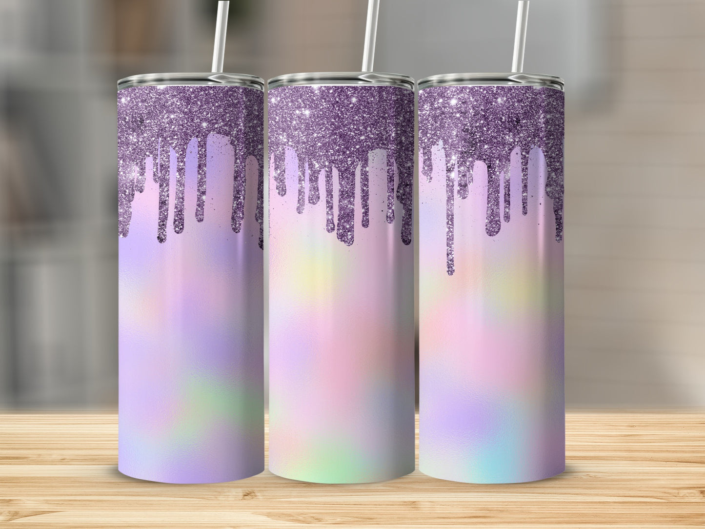 Three glitter-dripping tumblers with pastel tie-dye design on a wood surface.