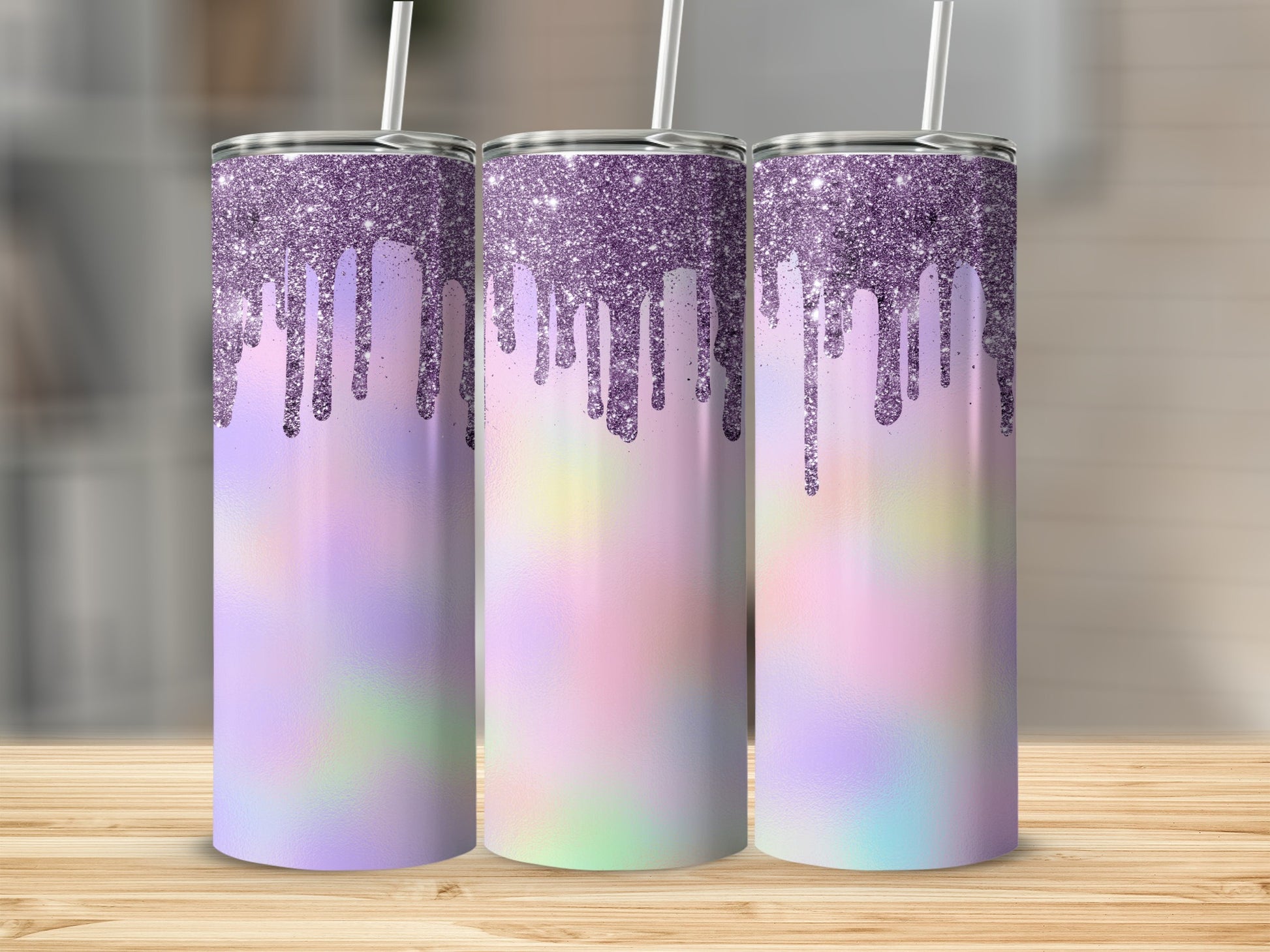 Three glitter-dripping tumblers with pastel tie-dye design on a wood surface.