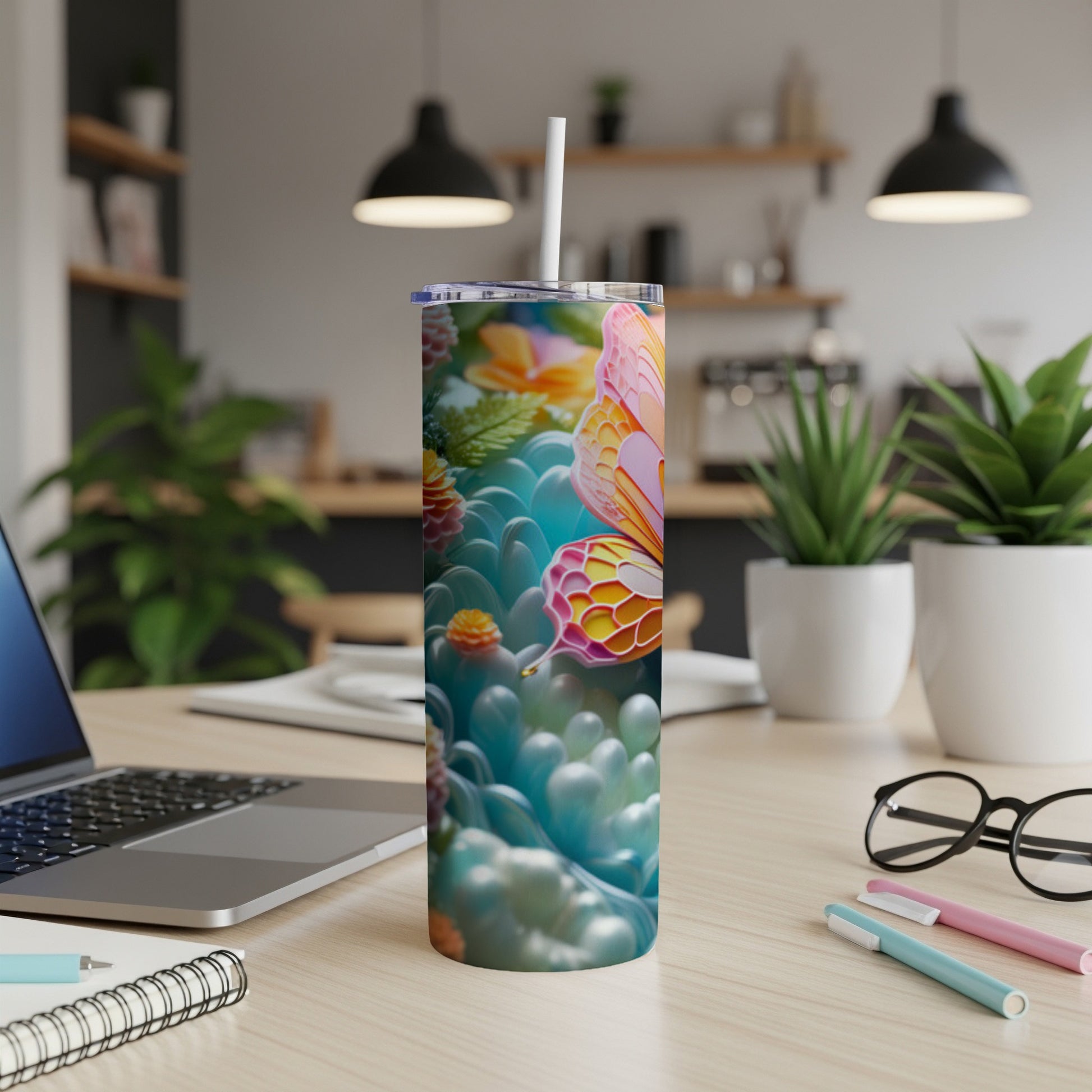 Tumbler with colorful butterfly and floral pattern on a desk.