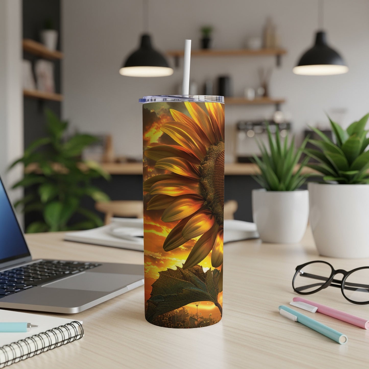 Sunflower tumbler with sunset sky background, on a desk with laptop.
