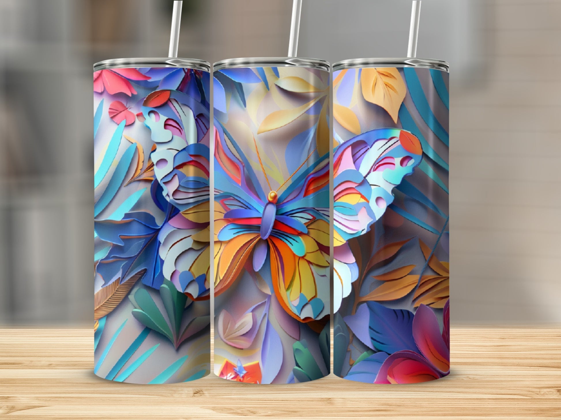 Three tumblers with colorful, layered butterfly and floral designs.