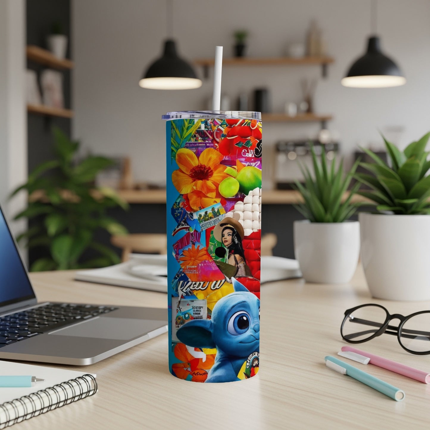 Blue alien character on a colorful collage tumbler with desk accessories.
