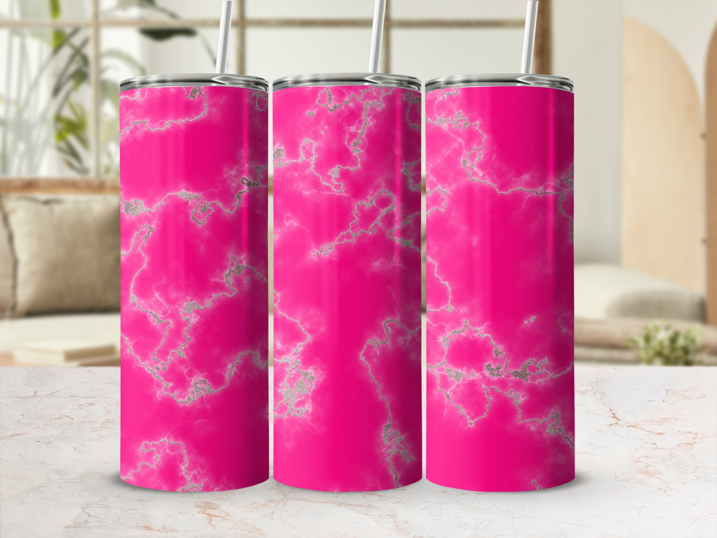 Three pink marble tumblers with silver accents and straws.