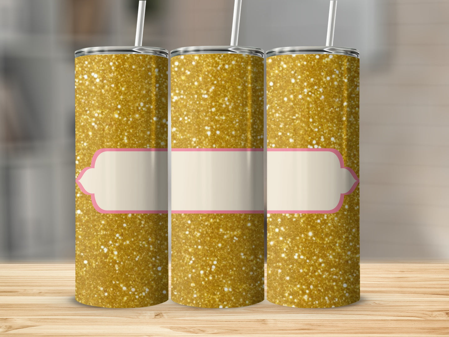 Three glitter tumblers with blank pink and cream label on wooden surface.