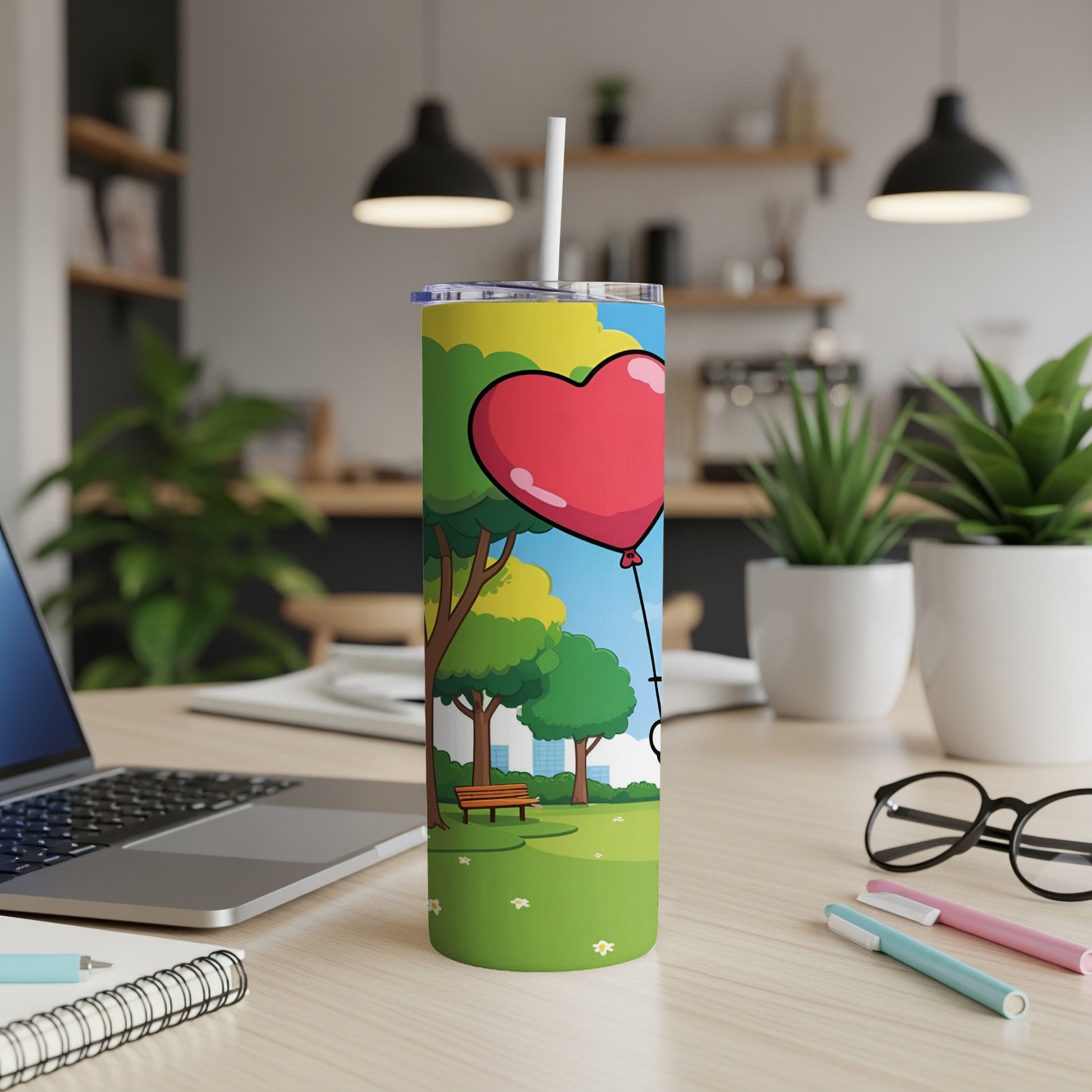 Tumbler with red heart balloon design on a desk.