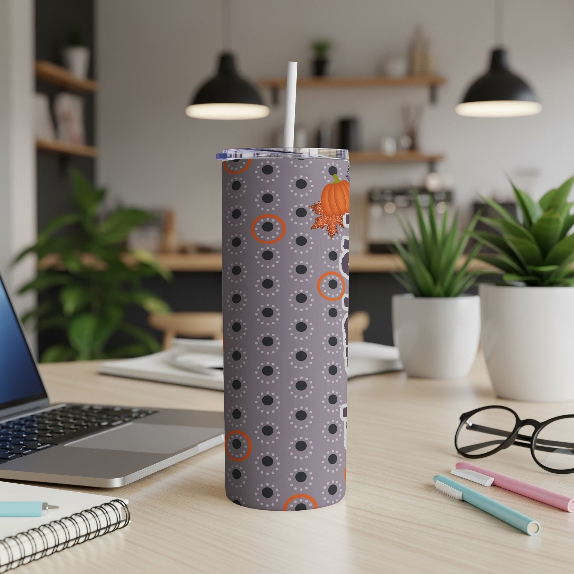 Gray tumbler with pumpkins and orange circles pattern, white lid and straw.