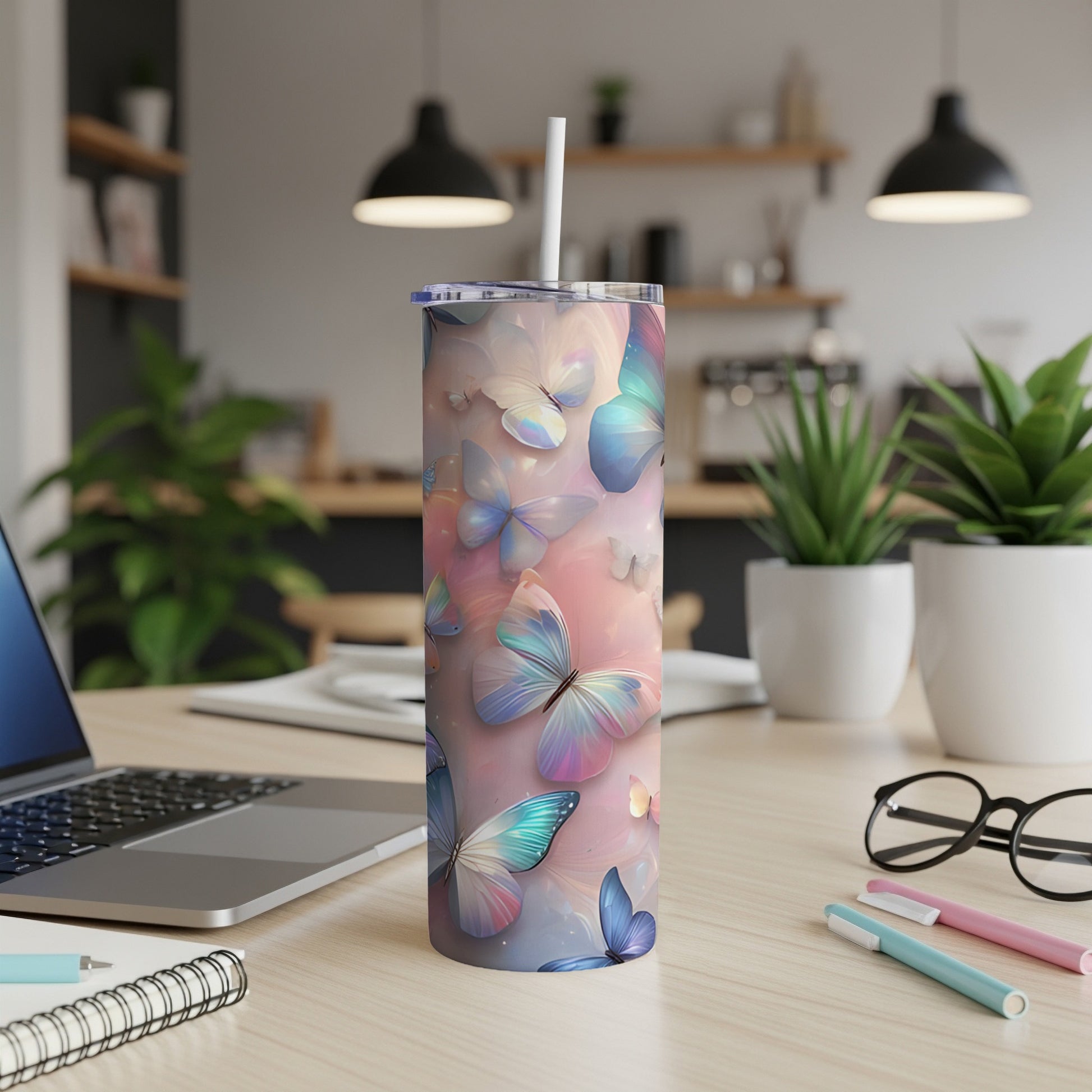 Pink and blue pastel butterflies wrap around a skinny tumbler with a straw.