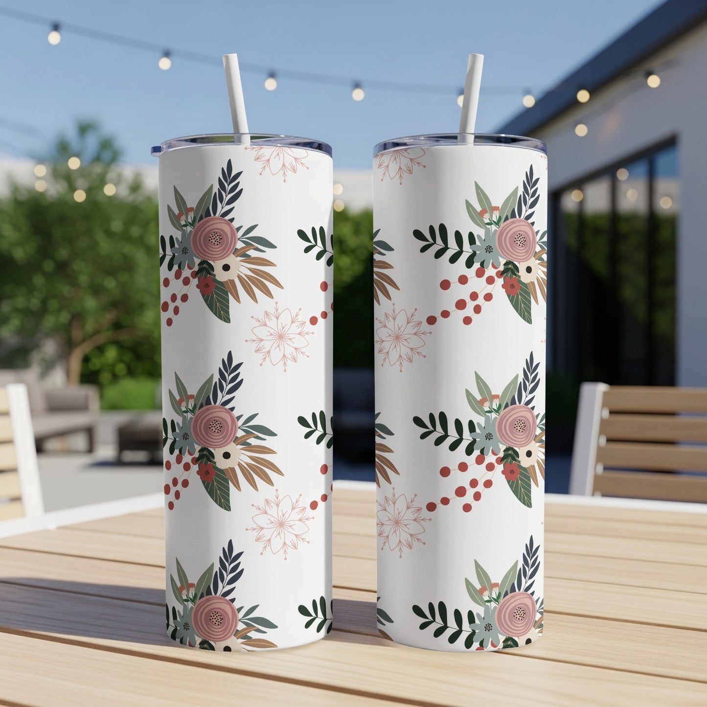 Two white tumblers with floral and snowflake pattern on a wooden table.