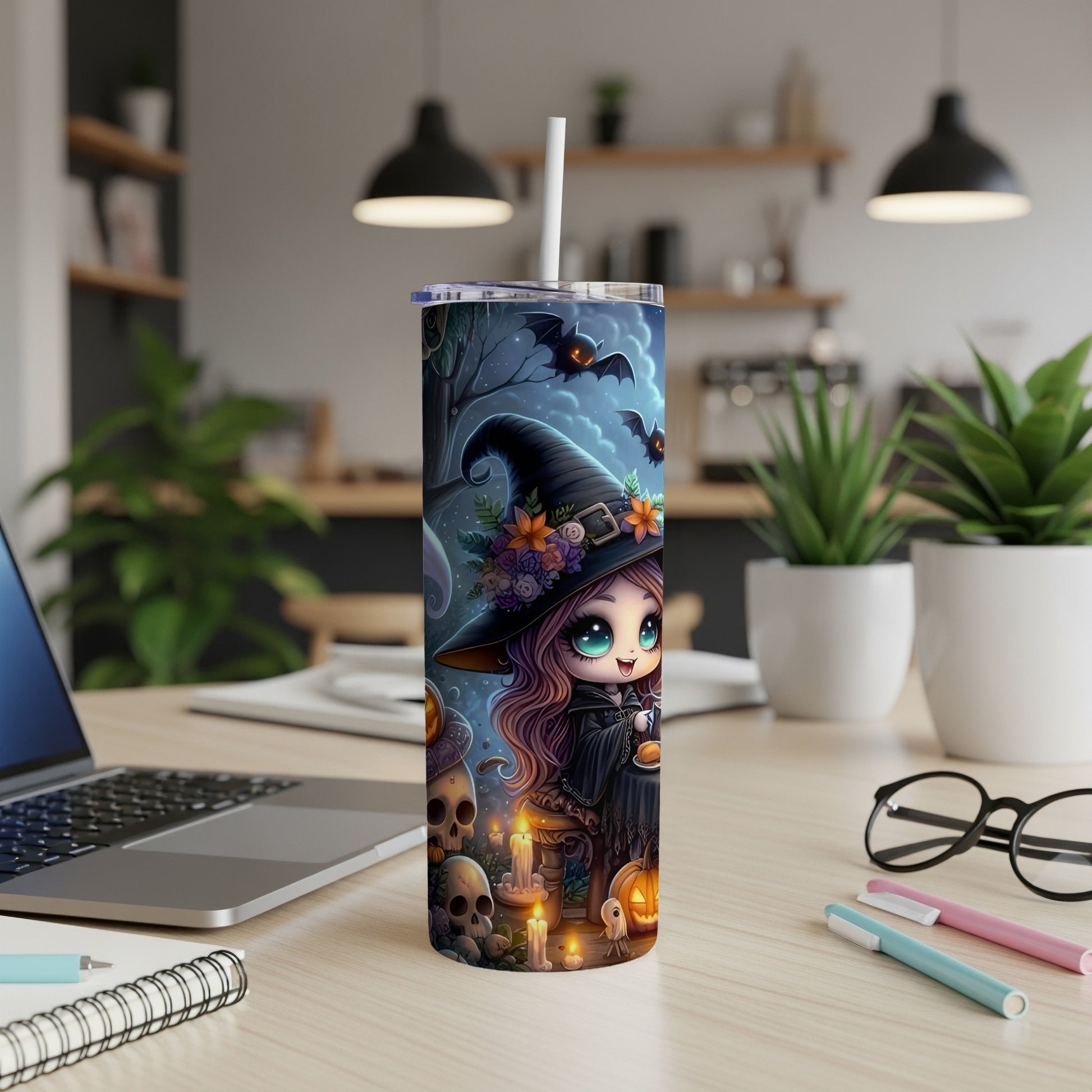 Tumbler with a cute witch design, bats, skulls, pumpkins, and candles on a table.