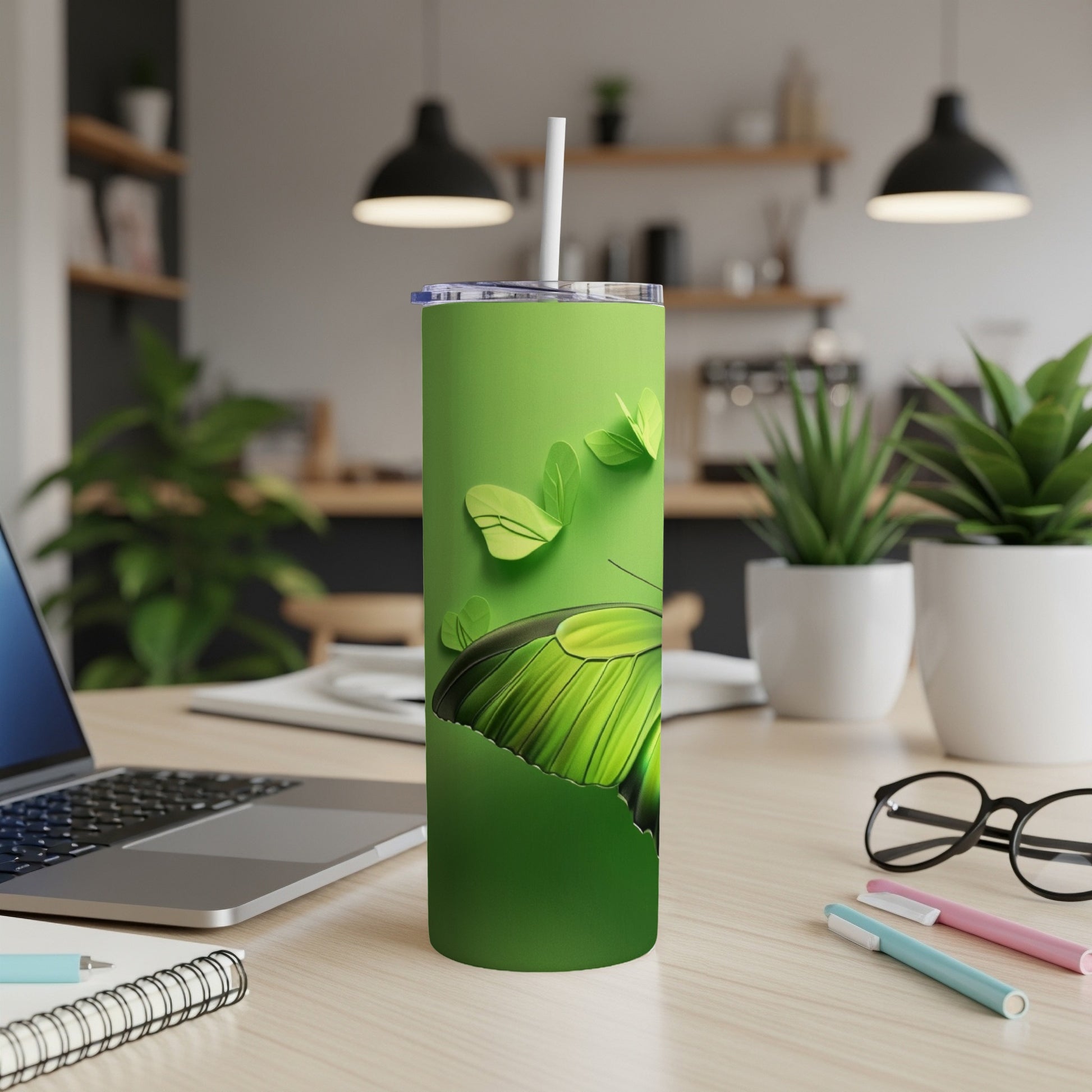 Green tumbler with a large green butterfly design, straw inserted.