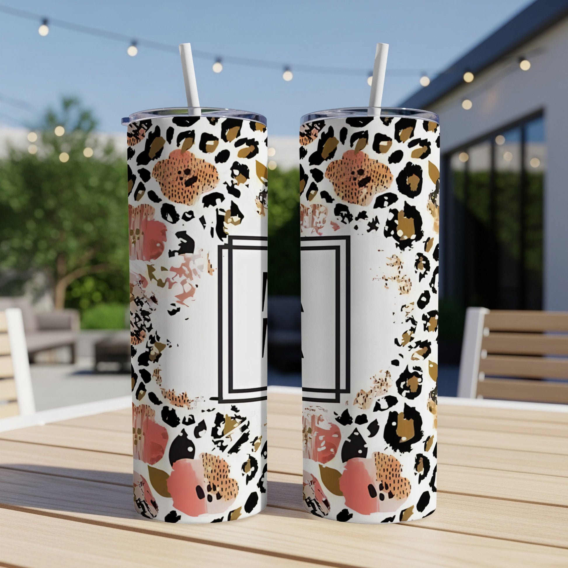 Two tumblers with floral and leopard print designs on a table.